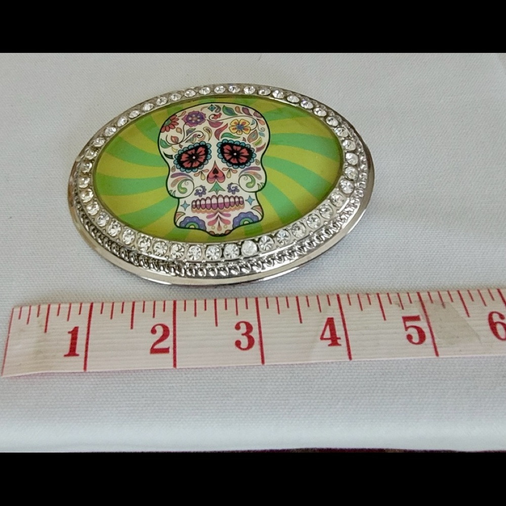 Skull belt buckle with rhinestone border.